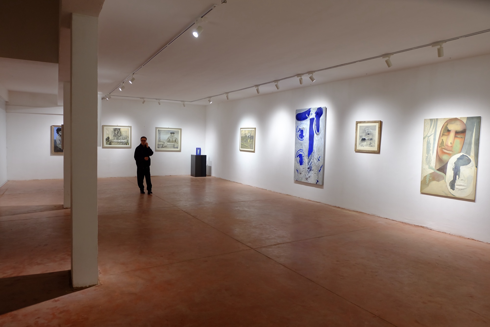 Vista panoramica della galleria con le opere esposte lungo le pareti.